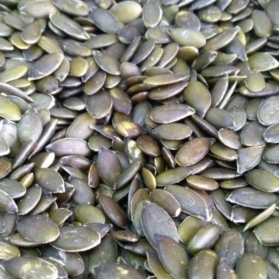 Sementes de abóbora verdes empilhadas umas sobre as outras.