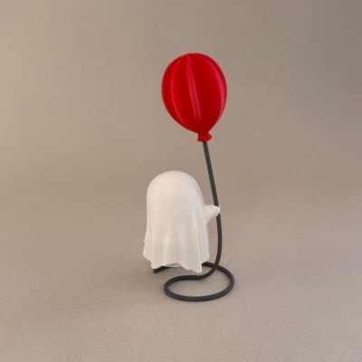 Escultura branca de fantasma com balão vermelho