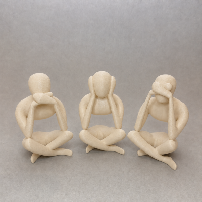 Três esculturas de bonecos sentados em poses com mãos na cabeça