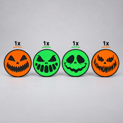 Discos redondos de Halloween com rostos assustadores em laranja e verde sobre fundo cinzento.