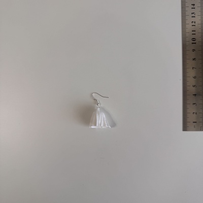 Brinco pendente branco com suporte prateado e régua de metal ao lado