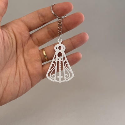 Chaveiro branco com ornamento religioso e cruz
