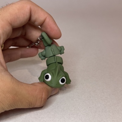 Chaveiro verde em forma de lagarto com olhos grandes