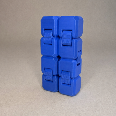 Fidget cube azul composto por seis cubos conectados sobre fundo cinzento