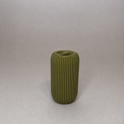 Recipiente cerâmico verde com textura e tampa em fundo cinzento.