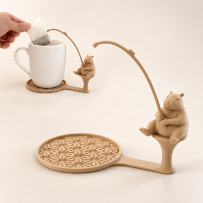 Suporte de chá em silicone castanho claro com design de capivaras a segurar canas de pesca