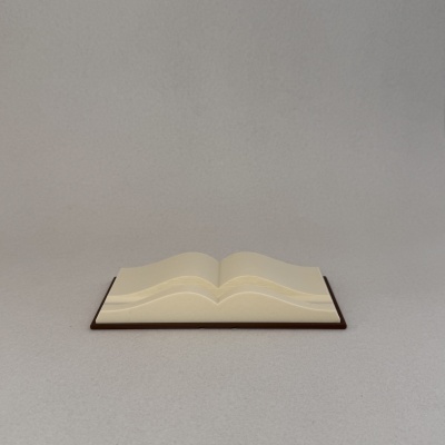 Livro aberto com páginas em tom creme em cima de base castanha