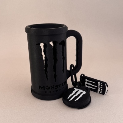 Caneca e porta-chaves Monster Energy pretos com logotipo branco.
