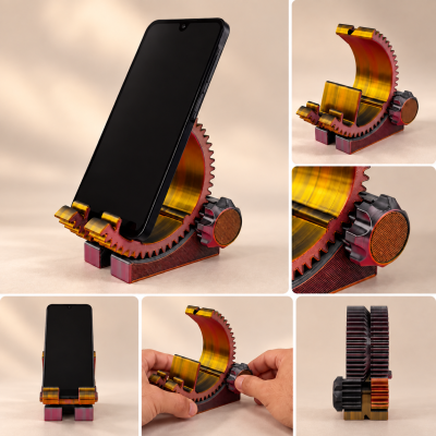 Suporte para telemóvel em forma de engrenagem com textura metálica amarela e vermelha, mostrando ajuste manual e telemóvel colocado.