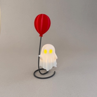 Figura fantasma branca com olhos amarelos segurando um balão vermelho