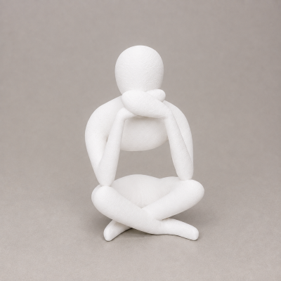 Escultura branca abstrata de figura humana sentada com mãos no queixo