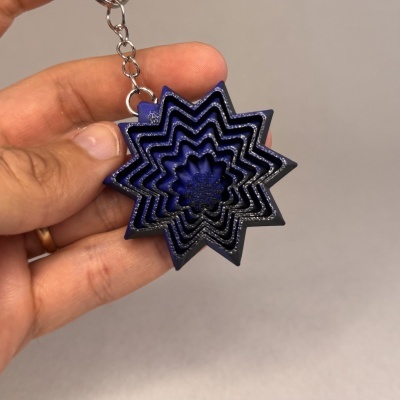 Chaveiro em forma de estrela azul com vários níveis sobre fundo cinzento