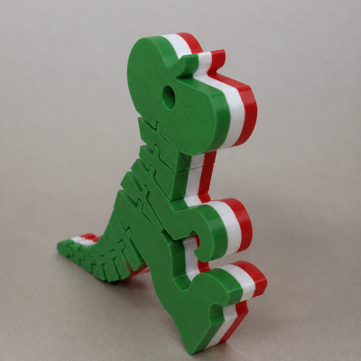 Peça decorativa de dinossauro verde com faixas verde, branco e vermelho nas laterais