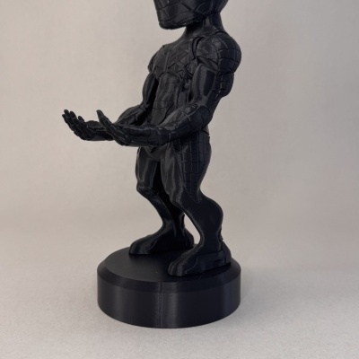 Figura de ação preta tipo Spider-Man com textura de teia em base circular preta.