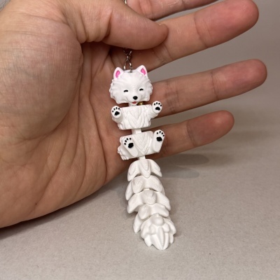 Chaveiro de cachorrinho branco com patas móveis segurado por mão