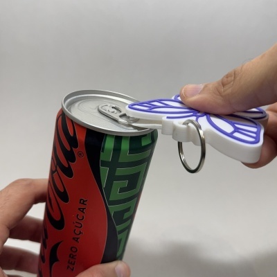 Lata de refrigerante com abridor de latas em chaveiro sendo usada