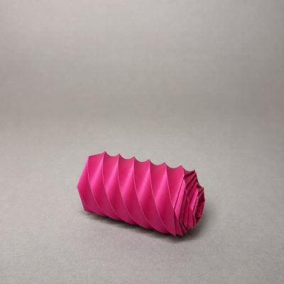 Rolo de tecido rosa com padrão espiral sobre superfície cinza