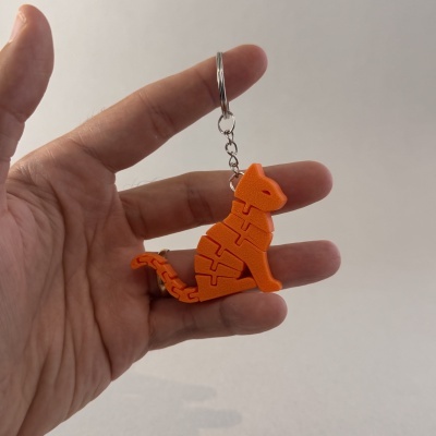 Chaveiro laranja dinossauro articulado na mão