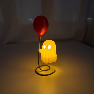 Candeeiro de mesa em forma de fantasma iluminado a segurar um balão vermelho