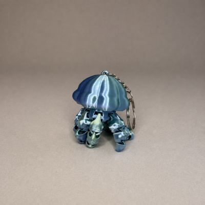 Chaveiro em forma de polvo azul metálico com corrente prateada