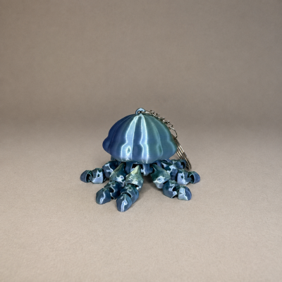 Chaveiro metálico em forma de polvo azul com pernas enroladas
