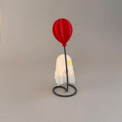 Objeto decorativo com figura fantasma branca e balão vermelho