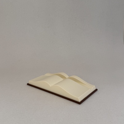 Livro aberto com páginas onduladas creme sobre base de madeira escura