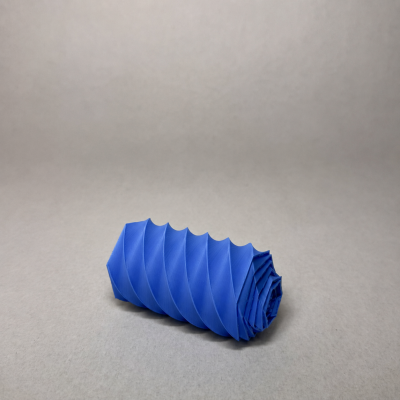 Objeto azul cilíndrico com textura espiral sobre superfície bege