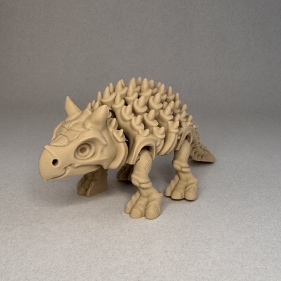 Figura de dinossauro Ankylosaurus bege com espinhos sobre fundo cinzento