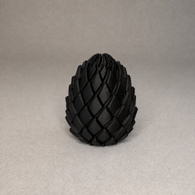 Objeto preto em forma de cone com padrão entrelaçado em relevo sobre fundo cinza