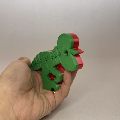 Objeto plástico verde e vermelho em forma de boneco humano na mão