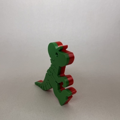 Peças de encaixe verdes e vermelhas formando dinossauro em fundo branco.