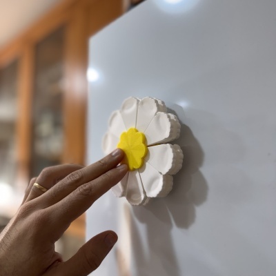 Íman flor branco com centro amarelo na porta de frigorífico