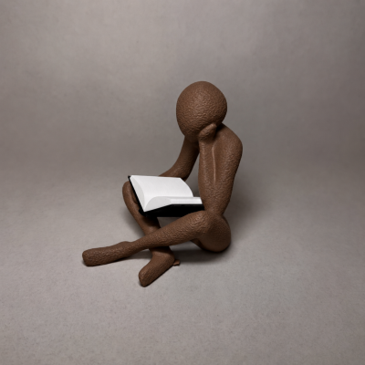 Escultura de figura humana castanha a ler um livro