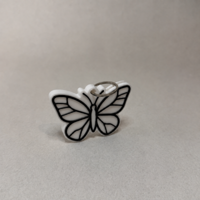 Porta-chaves borboleta plástico branco com detalhes pretos e argola metálica.