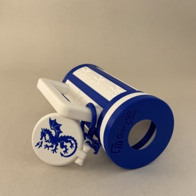 Brinquedo em plástico azul e branco com dragão azul, formato de trator, em fundo bege