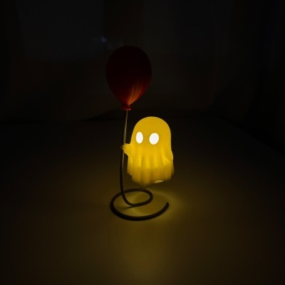 Candeeiro fantasma amarelo iluminado com balão vermelho