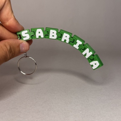 Chaveiro flexível verde e branco com o nome SABRINA