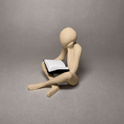 Escultura de figura humana a ler um livro aberto com capa preta