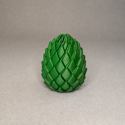 Figura decorativa verde com padrão tipo pinecone sobre fundo cinza