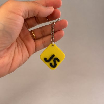 Porta-chaves amarelo com letras JS pretas segurado por mão