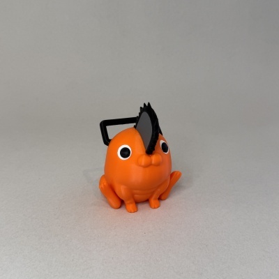 Figura de plástico laranja com olhos grandes e cauda pequena