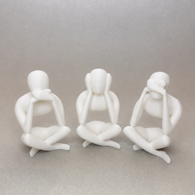 Três esculturas abstratas brancas de figuras humanas sentadas com pernas cruzadas e mãos no rosto