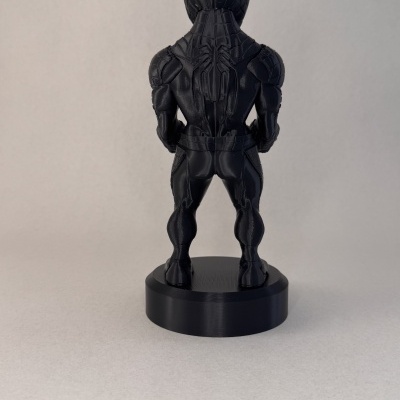 Estatueta preta de personagem de costas sobre base redonda
