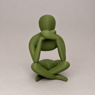 Estatueta decorativa verde em forma de figura humana abstrata sentada com pernas cruzadas