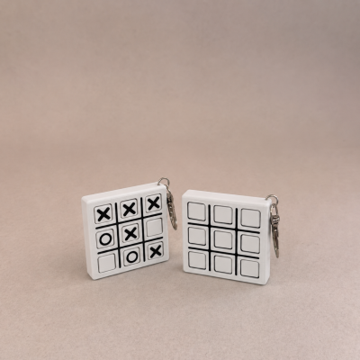 Dois tabuleiros de jogo da velha com peças deslizantes em branco e preto, sobre fundo bege.