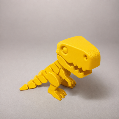 Figura de dinossauro amarela impressa em 3D sobre fundo cinza