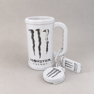 Caneca branca com logo Monster Energy e chaveiros com o mesmo logotipo