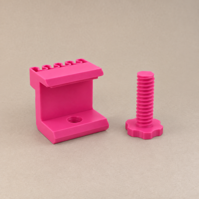 Suporte e parafuso rosa em plástico sobre fundo bege