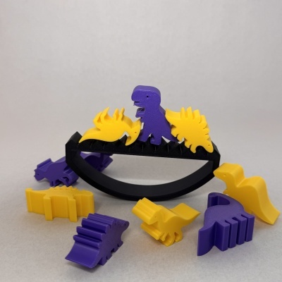 Brinquedo de encaixe com dinossauros em plástico amarelo e roxo numa base curva preta.